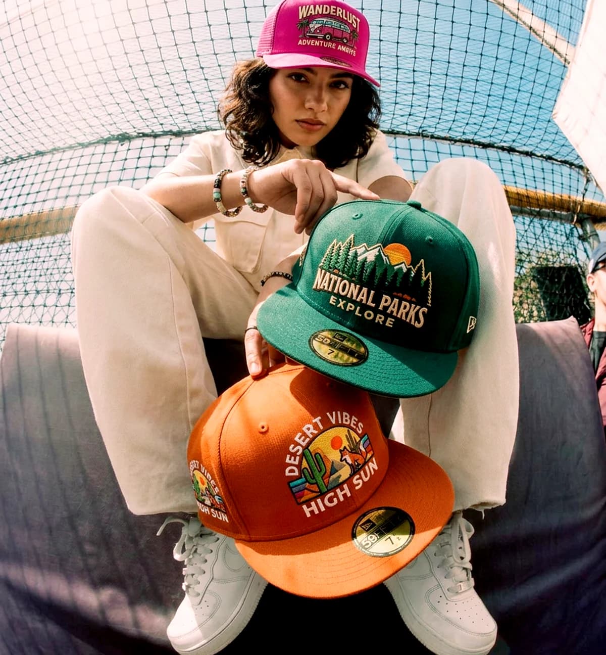 Model presenting embroidered fashion caps in a lifestyle setting